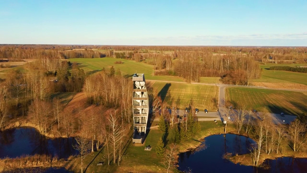 Kirkilai的现代建筑瞭望塔。绿色自然与池塘在日落的Birzai Eldership, Panevezys县，立陶宛。4K UHD令人惊叹的空中Dron拍摄视频素材