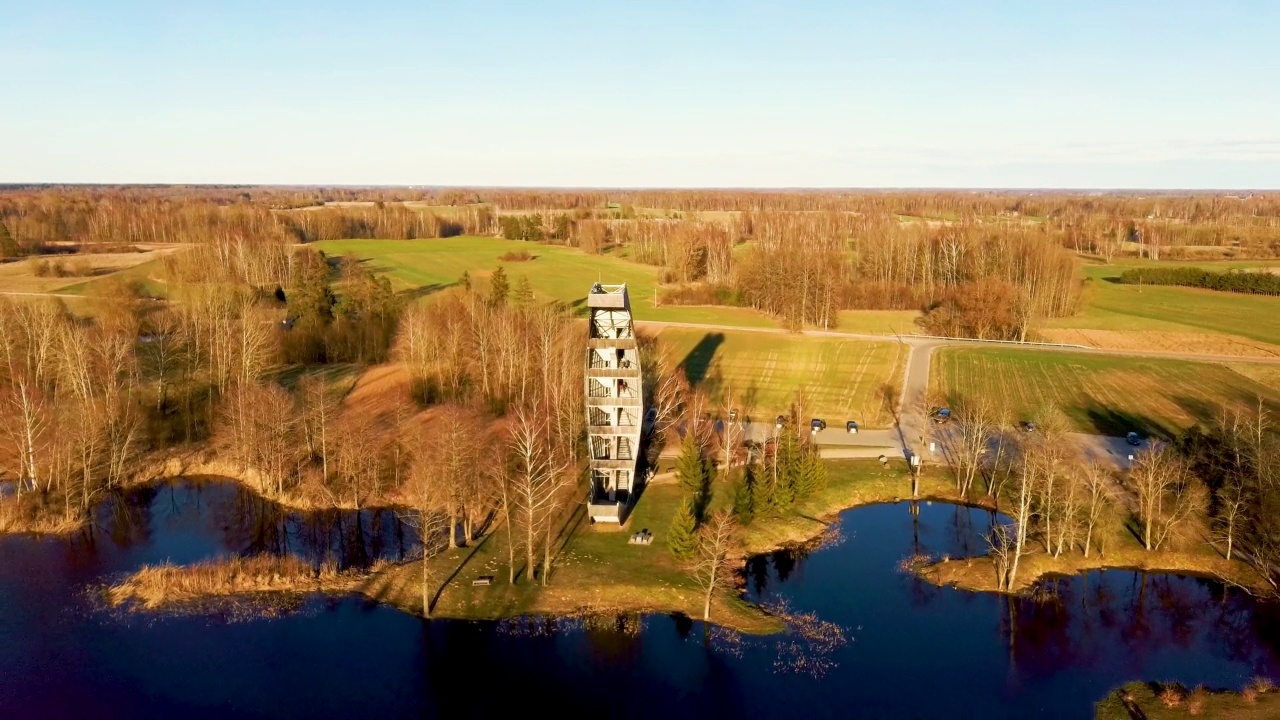 Kirkilai的现代建筑瞭望塔。绿色自然与池塘在日落的Birzai Eldership, Panevezys县，立陶宛。4K UHD令人惊叹的空中Dron拍摄视频素材