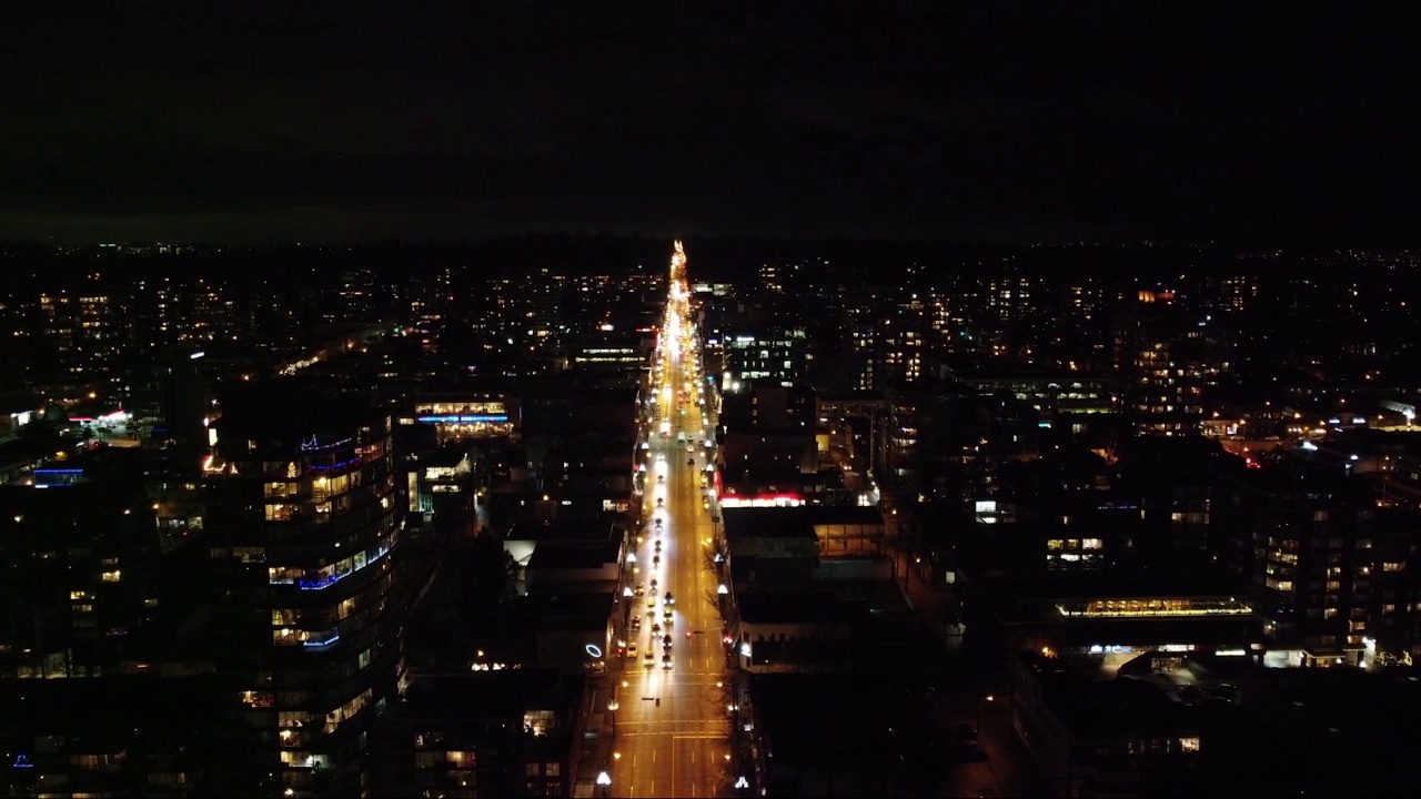 夜空中明亮的公路在黑暗的城市上空的鸟瞰图视频素材