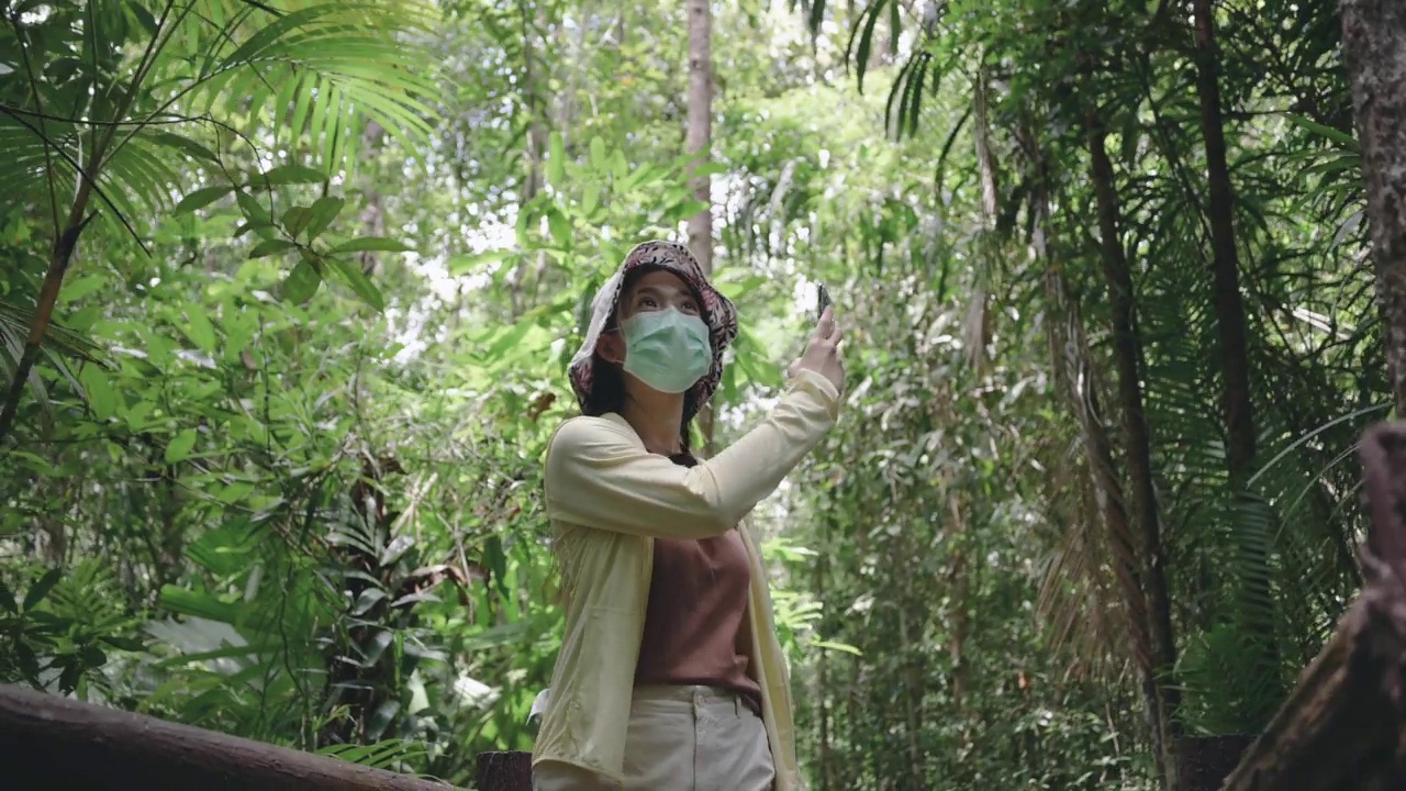 独自徒步旅行在翡翠池泰国甲米拍摄自然绿色森林的视频徒步旅行者手拿5g / 6g互联网智能手机行走在雨林中视频素材