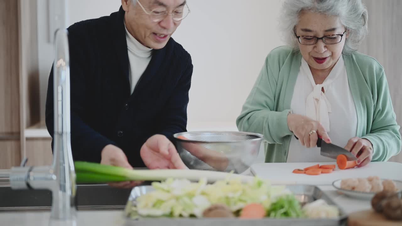 老夫妇带着平板电脑，一起在家做饭。视频素材