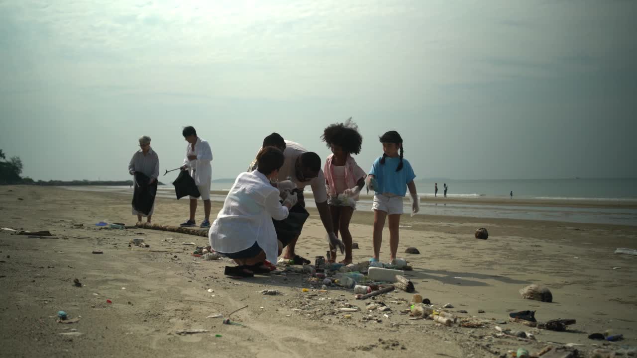 志愿者活动，家庭帮助在海滩上捡垃圾视频下载