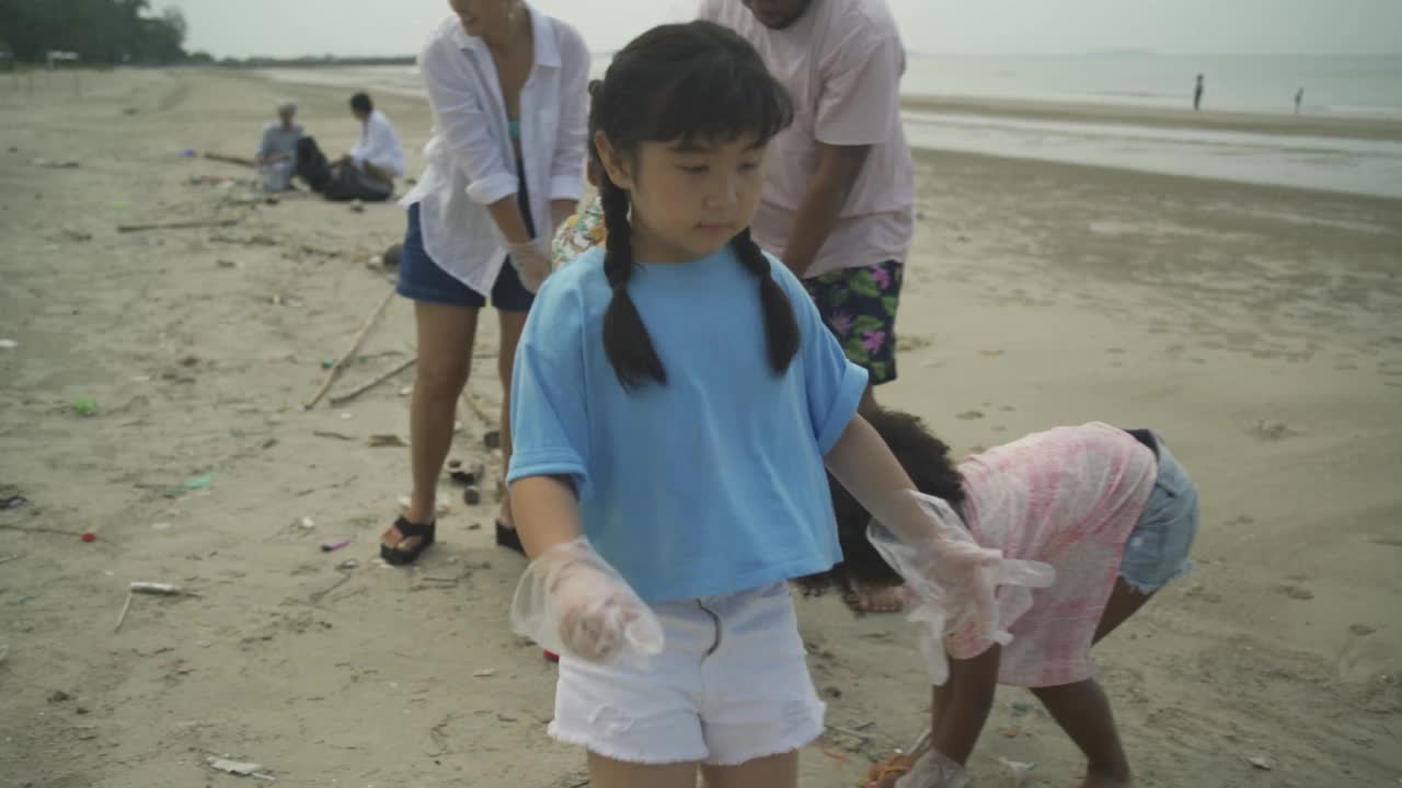 志愿者活动，家庭帮助在海滩上捡垃圾视频下载