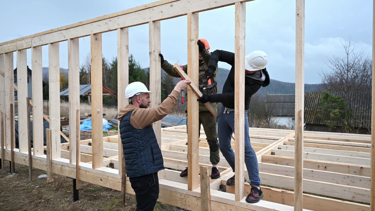 男子工人在建造木制框架房屋时敲击。视频素材