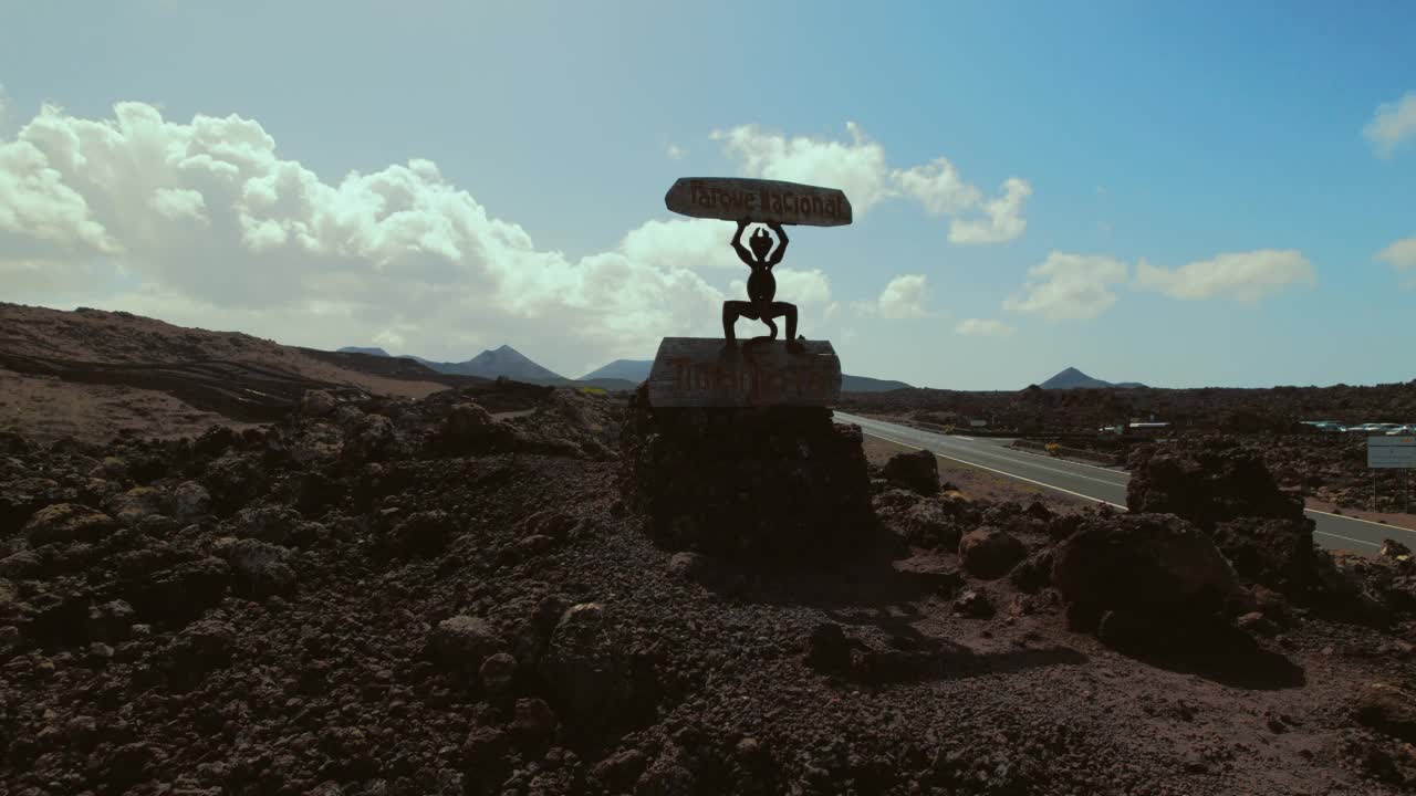 无人机拍摄的空旷道路沿着蒂曼法亚国家公园的岩石火山自然景观。加那利群岛，兰萨罗特，西班牙。没有人视频素材