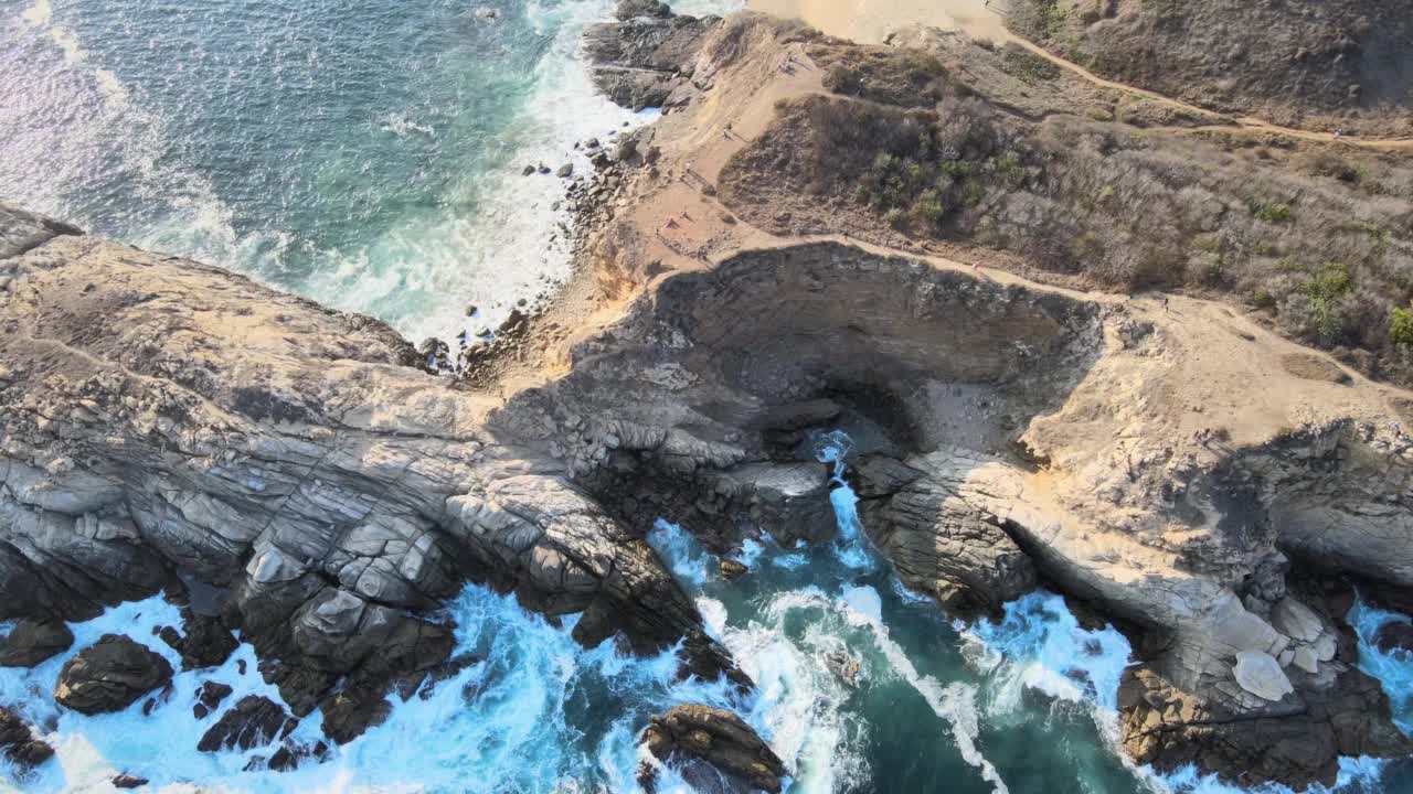 海浪拍打着墨西哥瓦哈卡蓬塔科米塔的石头。视频下载