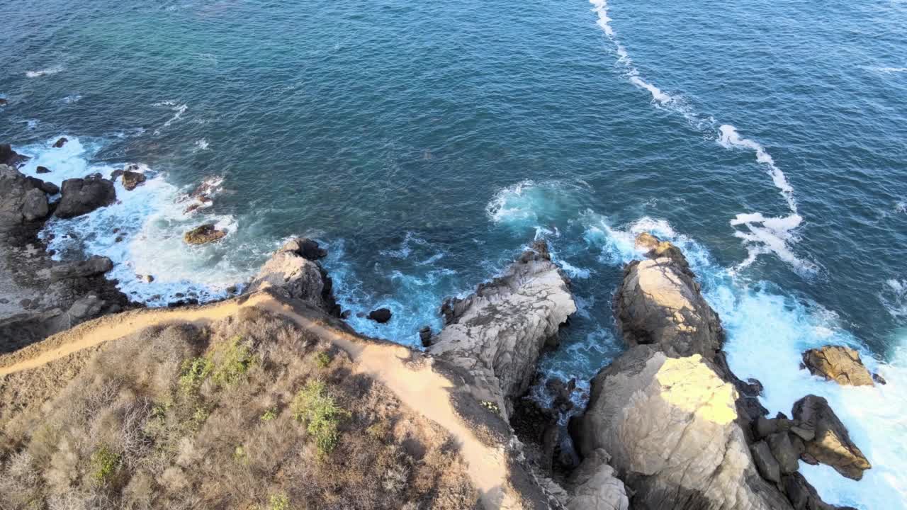 墨西哥瓦哈卡的蓬塔科梅塔(Punta Cometa)，海浪拍打着石头。视频下载