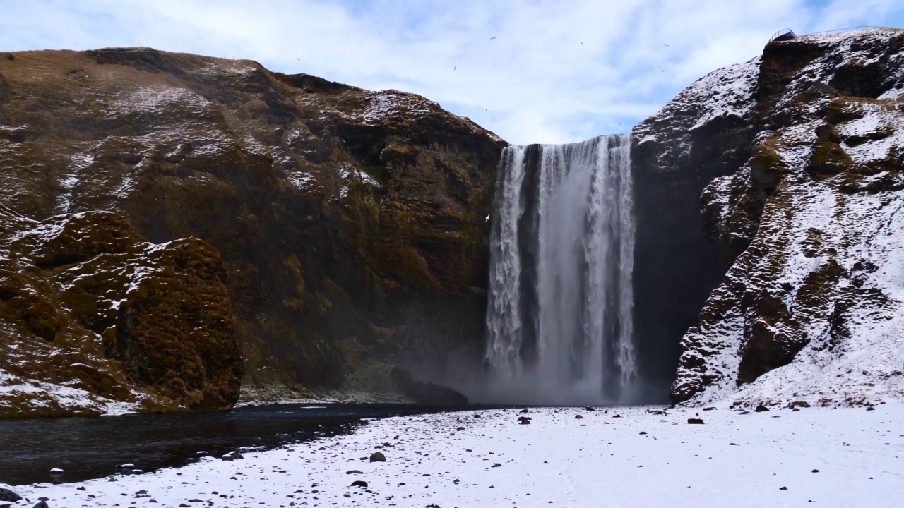 美丽的瀑布Skógafoss(高60米)，在冬季，冰岛南海岸靠近环路的一个热门旅游目的地。视频素材