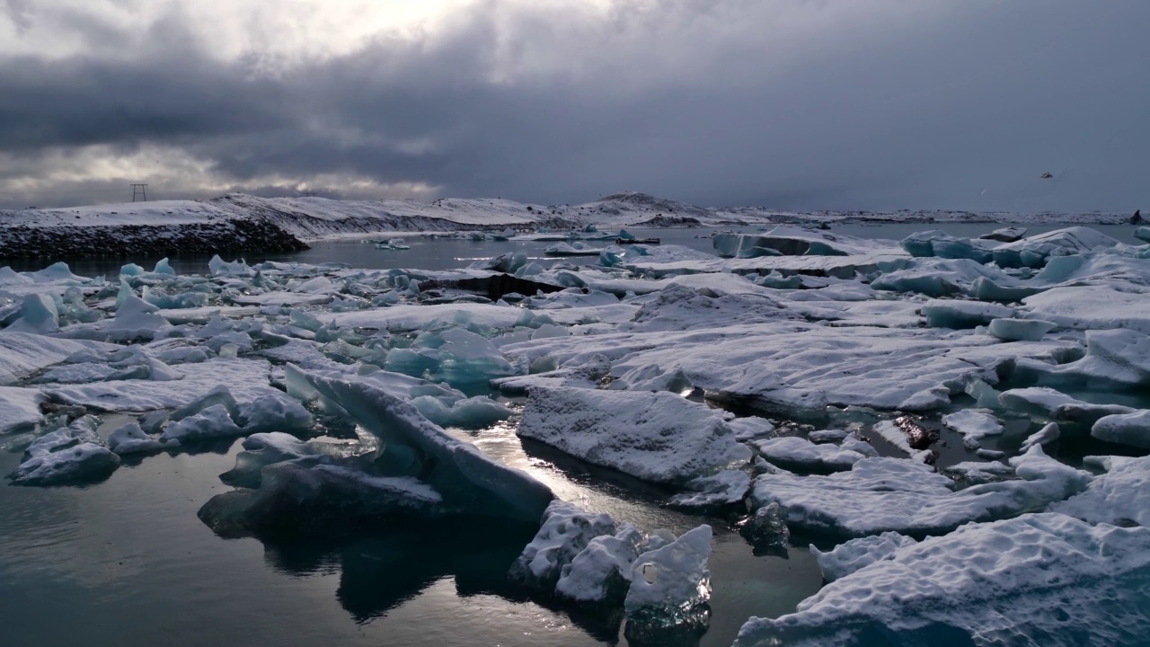 著名的冰川湖Jökulsárlón的迷人景色，位于冰岛南部Vatnajökull国家公园，漂浮的冰山和阳光穿透云层。视频素材