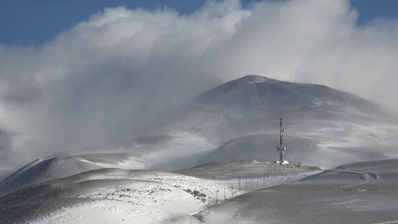 阿尔泰库雷山冬季暴雪和强雪暴下中继塔的视频。视频素材