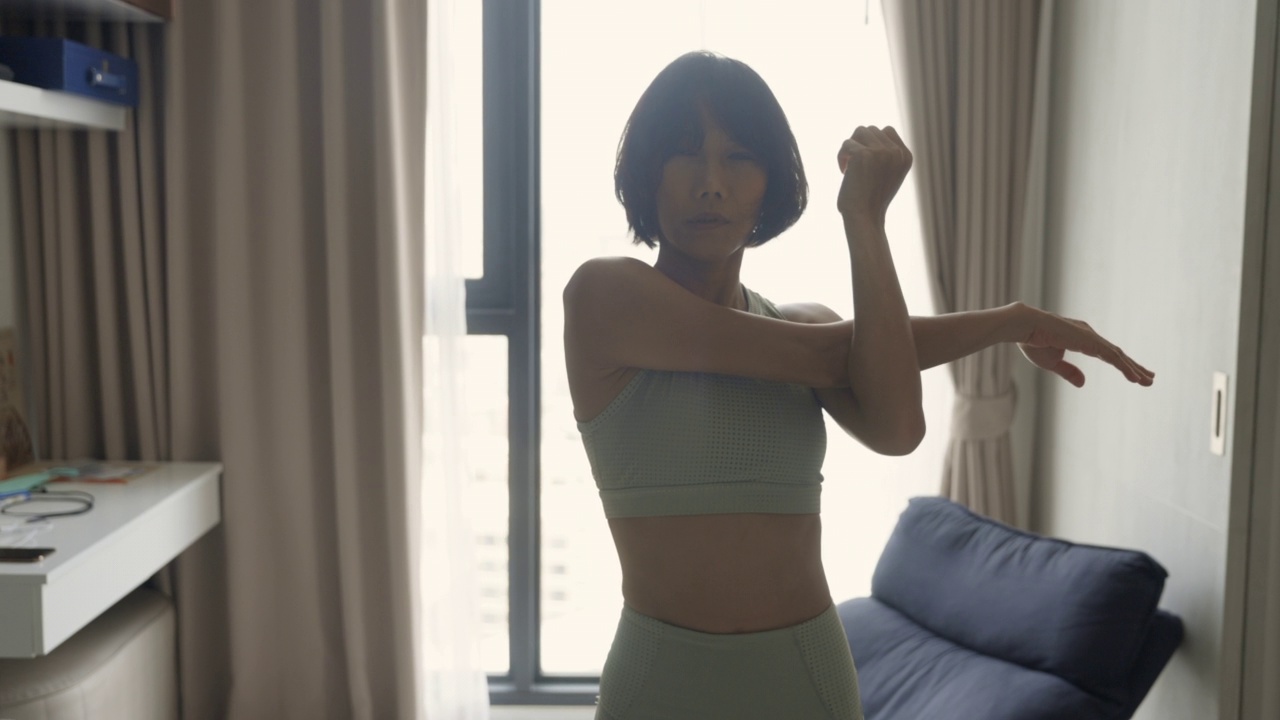 活跃的亚洲妇女在锻炼前伸展她的手臂视频素材