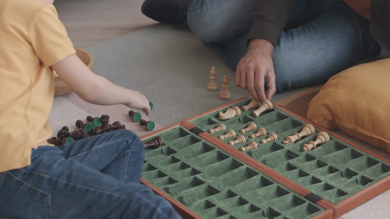 带着小儿子的男人在下棋后把棋子放在棋盘上视频素材