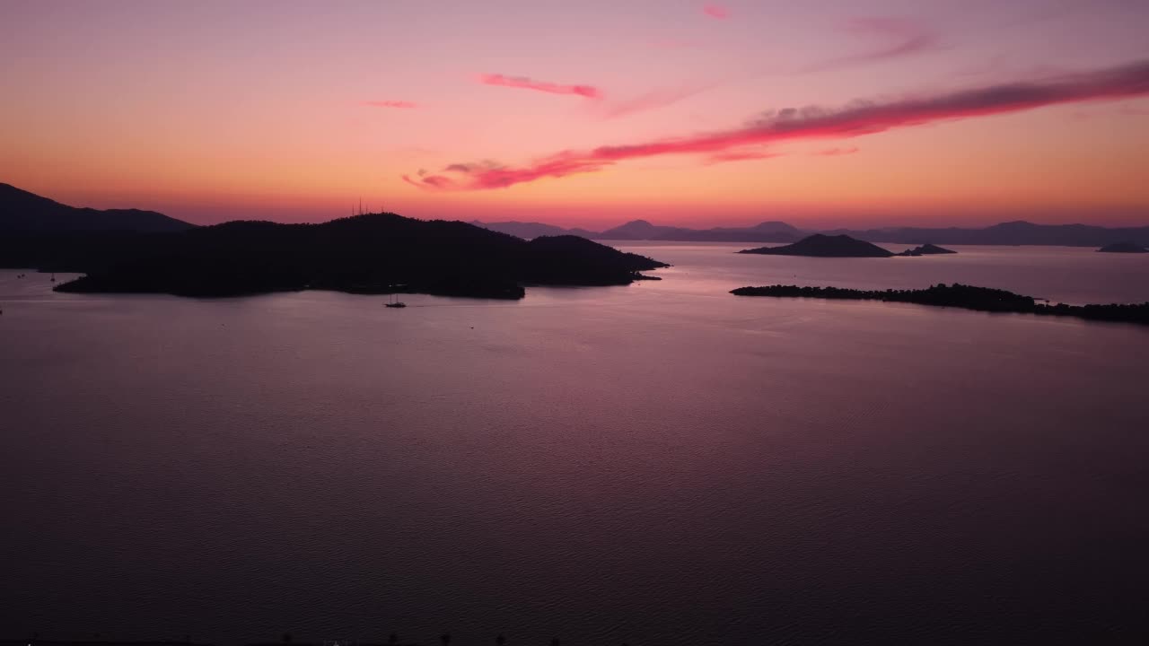 无人机拍摄的地中海沿岸岛屿上浪漫的粉红色日落视频素材