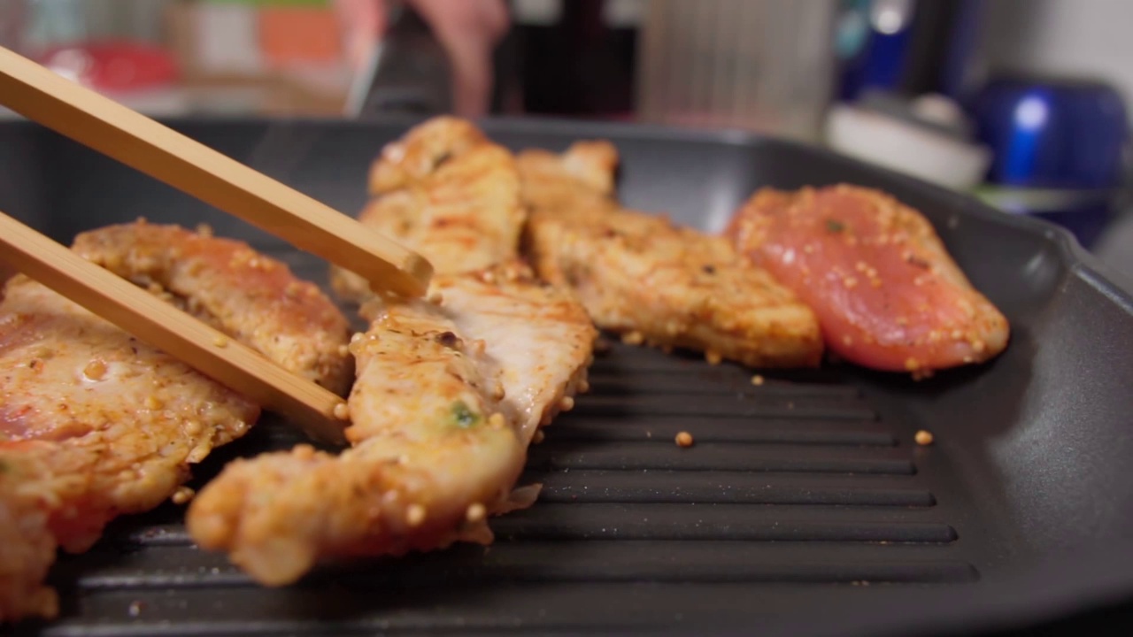 烹饪生牛排。鱼片，火鸡胸放在烤盘上。健康食品。慢动作视频素材