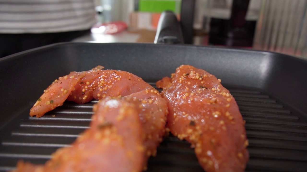 在烤盘上用香料烹饪火鸡牛排。健康食品。减肥和健身。有选择性的重点。慢动作视频素材