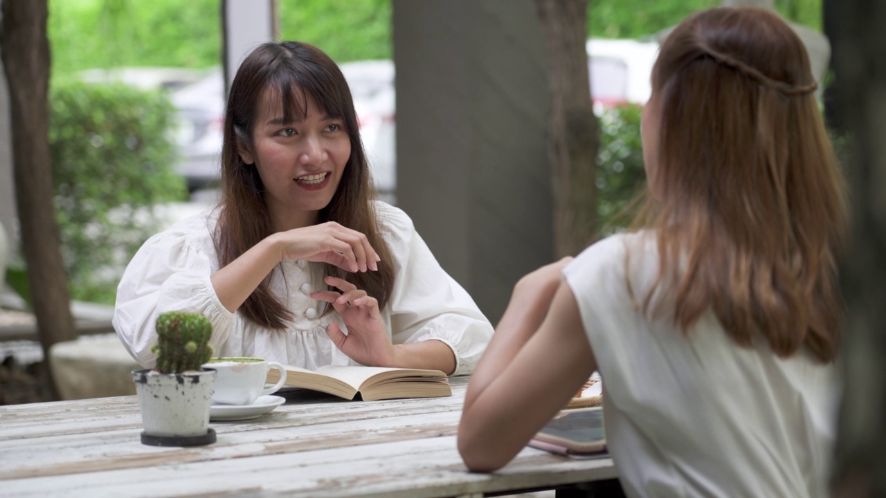 在咖啡店喝咖啡的年轻女性们愉快地交谈着。视频素材