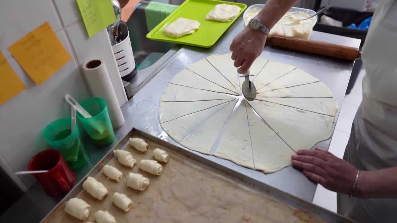 一名经验丰富的妇女在厨房柜台上制作羊角面包卷的视频视频素材