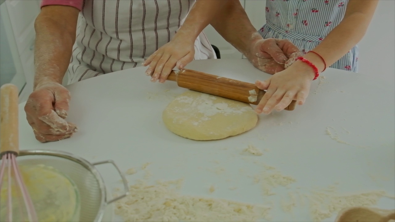 奶奶和孩子一起做面团。有选择性的重点。食物。视频素材