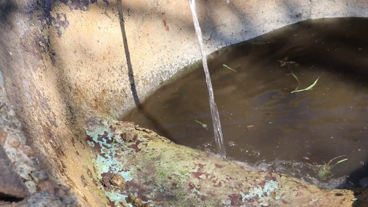 用水管把花园池塘的水灌满。视频素材