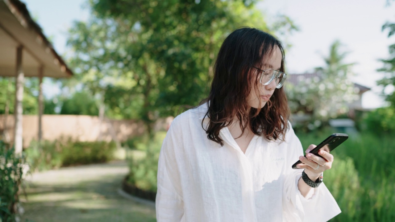 亚洲女性游客在度假胜地使用智能手机视频素材