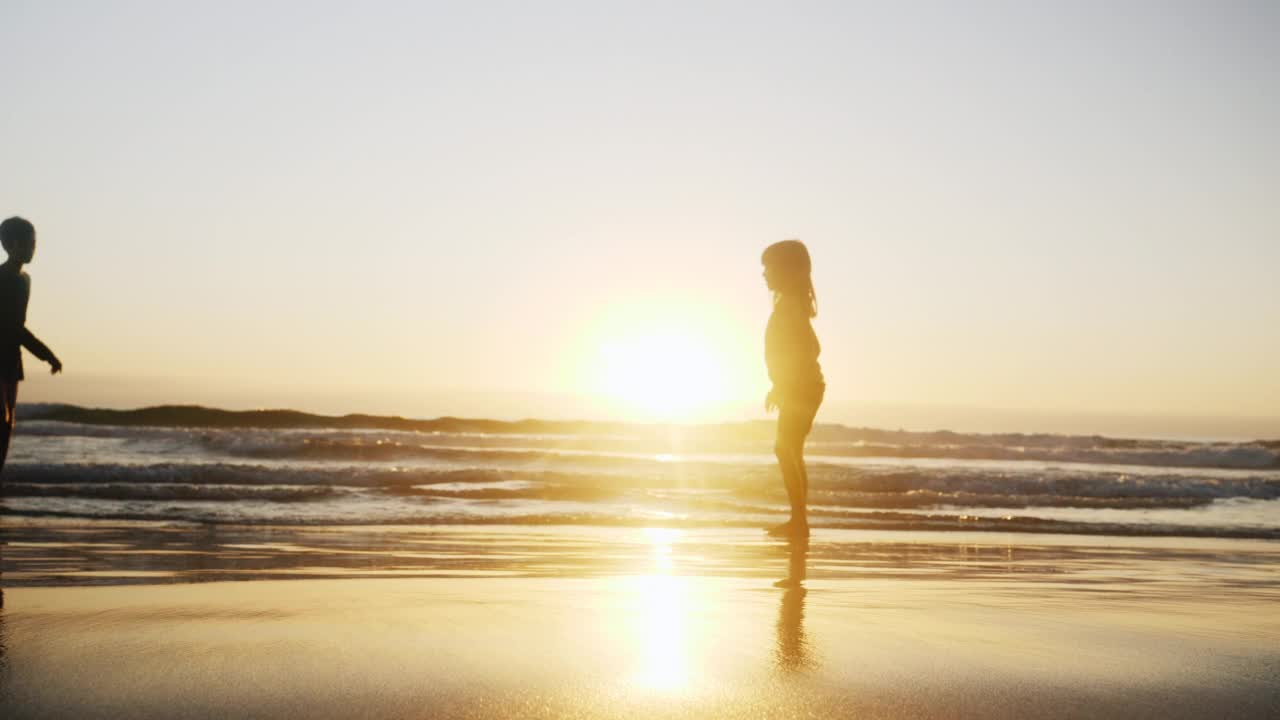 剪影家庭玩在海洋冲浪在海滩上日落视频素材