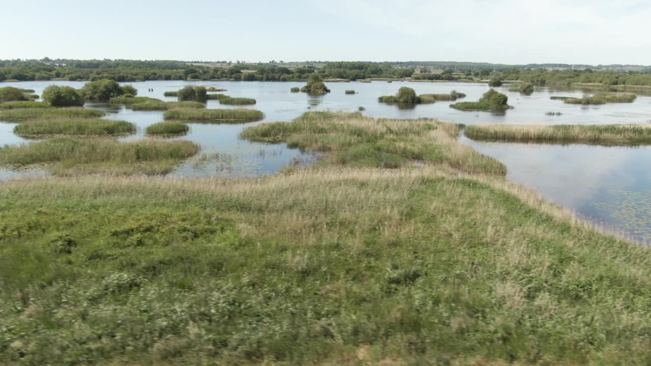 在英格兰被洪水淹没的沼泽上空飞行。视频素材