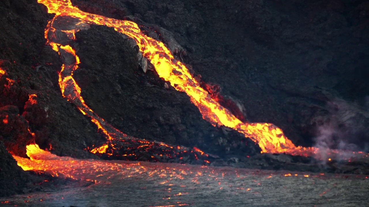 冰岛雷克雅尼半岛Fagradalsfjall山附近的Geldingadalir山谷火山喷发的近距离视图，在黑暗中流动的热熔岩。视频素材