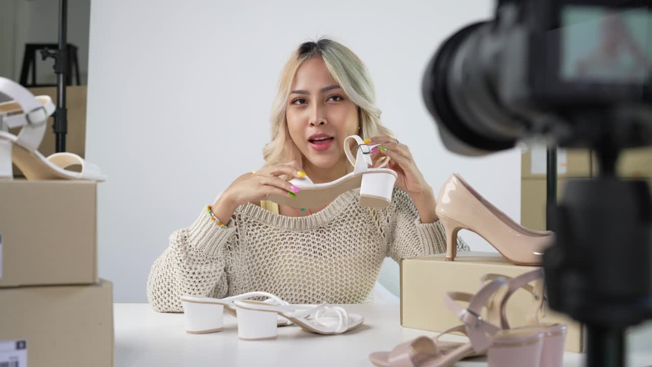 年轻迷人的亚洲女性博主或视频博主看着相机评价产品。现代女商人利用社交媒体进行营销。商业网络影响者对社交媒体的概念。视频素材