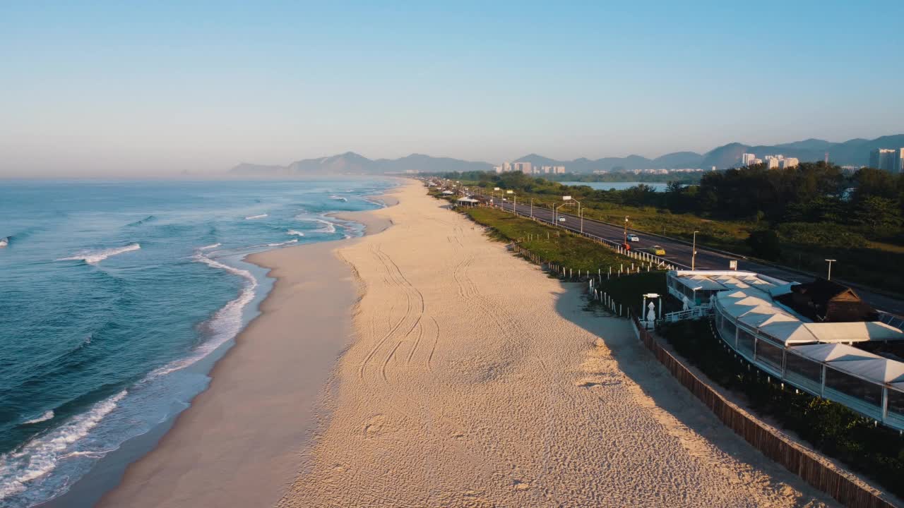 航拍Reserva海滩，Marapendi泻湖和Lucio Costa大道上的汽车交通。Barra da Tijuca和Recreio，在巴西的里约热内卢。日出。阳光明媚的一天。无人驾驶飞机。普拉达珍藏视频素材