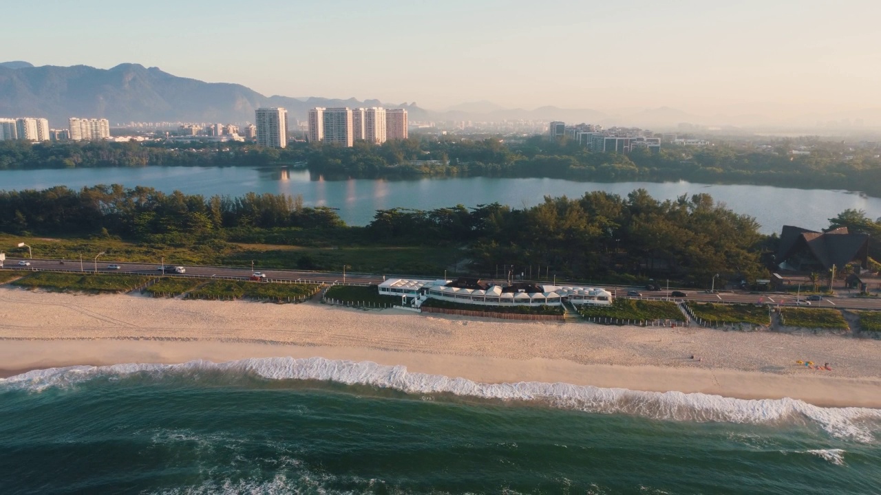 航拍Reserva海滩，Marapendi泻湖和Lucio Costa大道上的汽车交通。Barra da Tijuca和Recreio，在巴西的里约热内卢。日出。阳光明媚的一天。无人驾驶飞机。普拉达珍藏视频素材