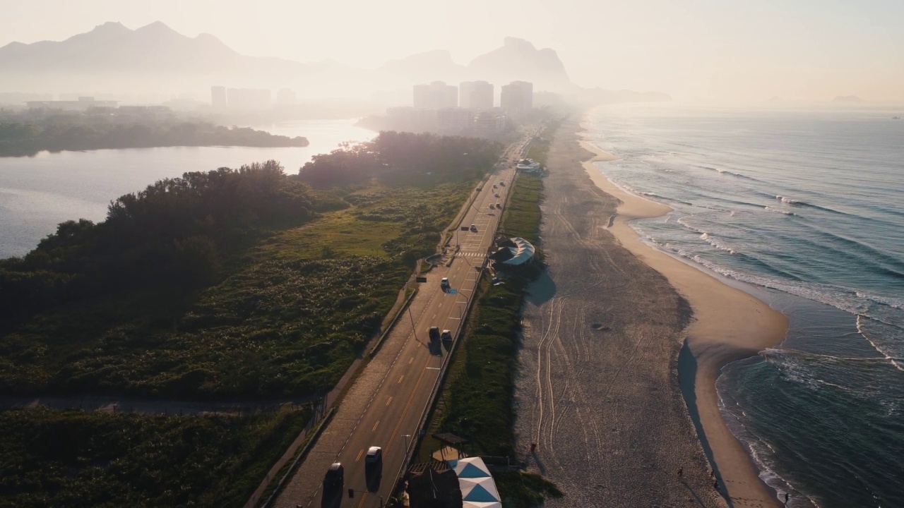 航拍Reserva海滩，Marapendi泻湖和Lucio Costa大道上的汽车交通。Barra da Tijuca和Recreio，在巴西的里约热内卢。日出。阳光明媚的一天。无人驾驶飞机。普拉达珍藏视频素材