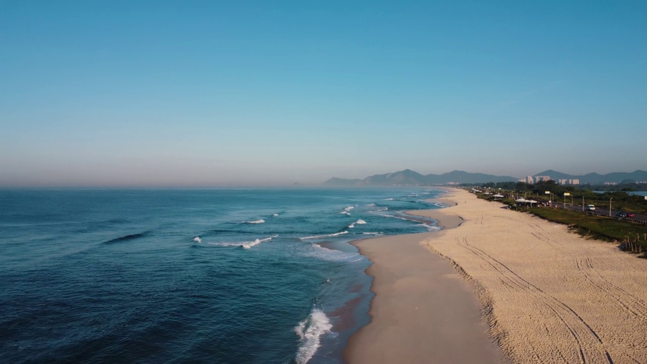 航拍Reserva海滩，Marapendi泻湖和Lucio Costa大道上的汽车交通。Barra da Tijuca和Recreio，在巴西的里约热内卢。日出。阳光明媚的一天。无人驾驶飞机。普拉达珍藏视频素材