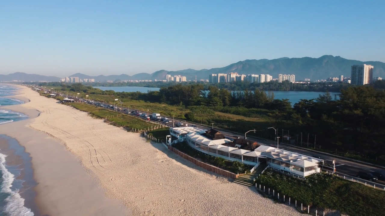 航拍Reserva海滩，Marapendi泻湖和Lucio Costa大道上的汽车交通。Barra da Tijuca和Recreio，在巴西的里约热内卢。日出。阳光明媚的一天。无人驾驶飞机。普拉达珍藏视频素材