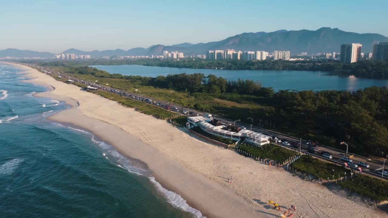 航拍Reserva海滩，Marapendi泻湖和Lucio Costa大道上的汽车交通。Barra da Tijuca和Recreio，在巴西的里约热内卢。日出。阳光明媚的一天。无人驾驶飞机。普拉达珍藏视频素材