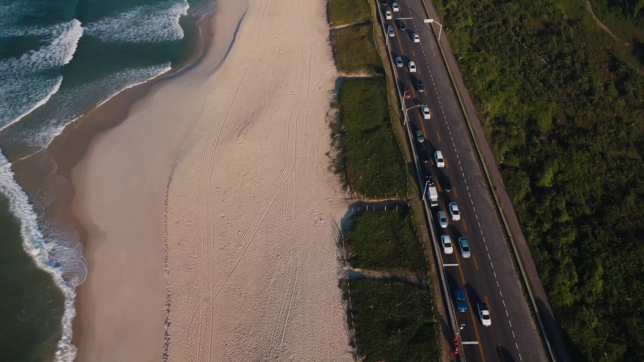 航拍Reserva海滩，Marapendi泻湖和Lucio Costa大道上的汽车交通。Barra da Tijuca和Recreio，在巴西的里约热内卢。日出。阳光明媚的一天。无人驾驶飞机。普拉达珍藏视频素材