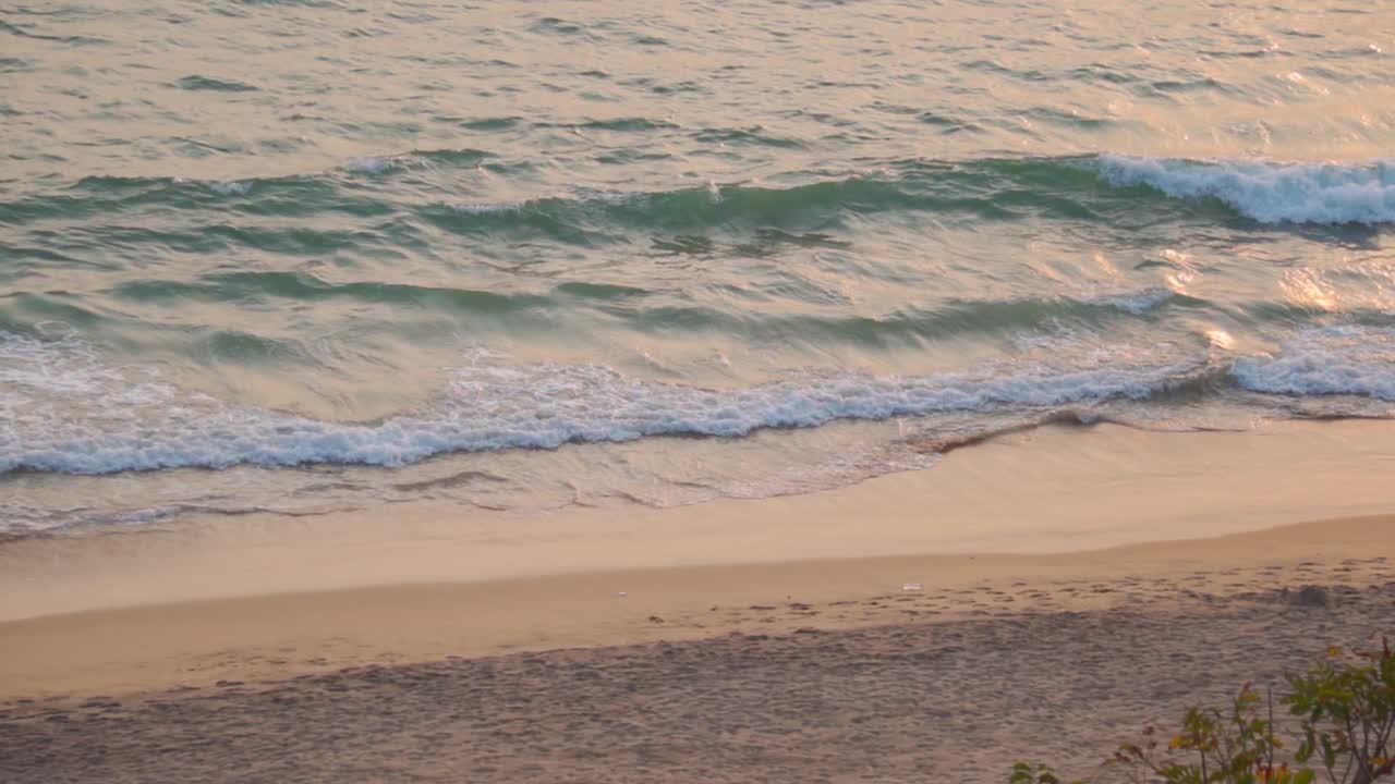 在印度南果阿的日落期间，海浪撞击卡波德拉马海滩的慢动作镜头。日落时海浪起伏。和平的自然背景。日落时海浪起伏。视频素材