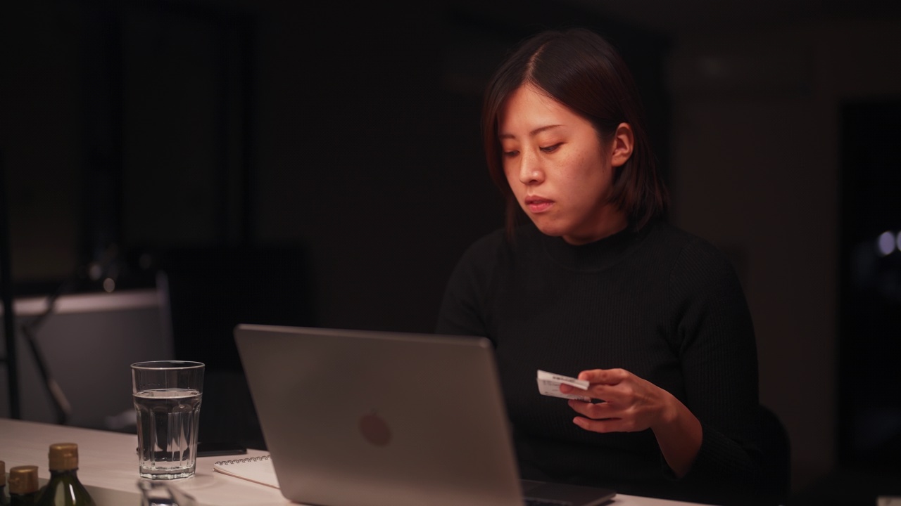 年轻女性在家里的客厅里用笔记本电脑做财务规划视频素材