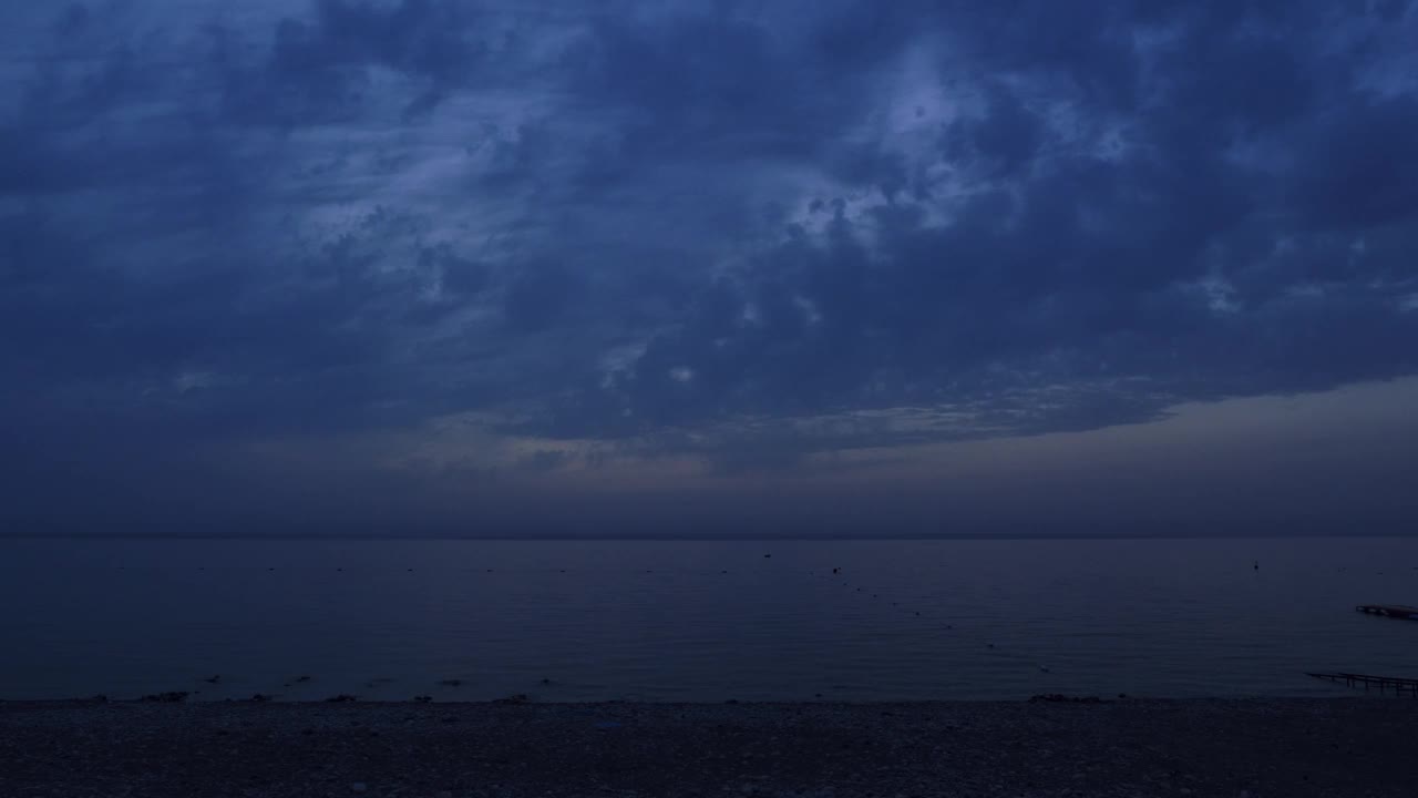 平静平静的海面在黄昏的阴天。海上的日出。日出时的天空背景。野生美丽的自然景观视频素材