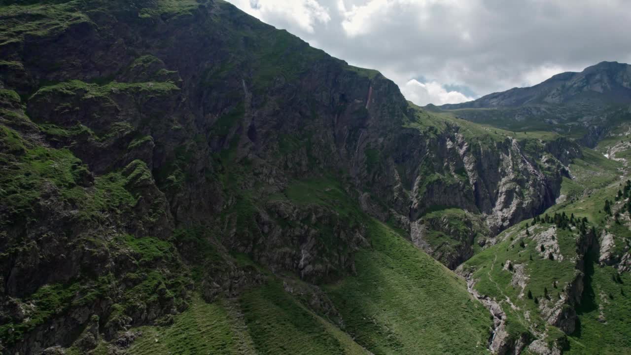 在高山峡谷的山坡上的一条汽车路。穿越山脉的假期旅行视频素材