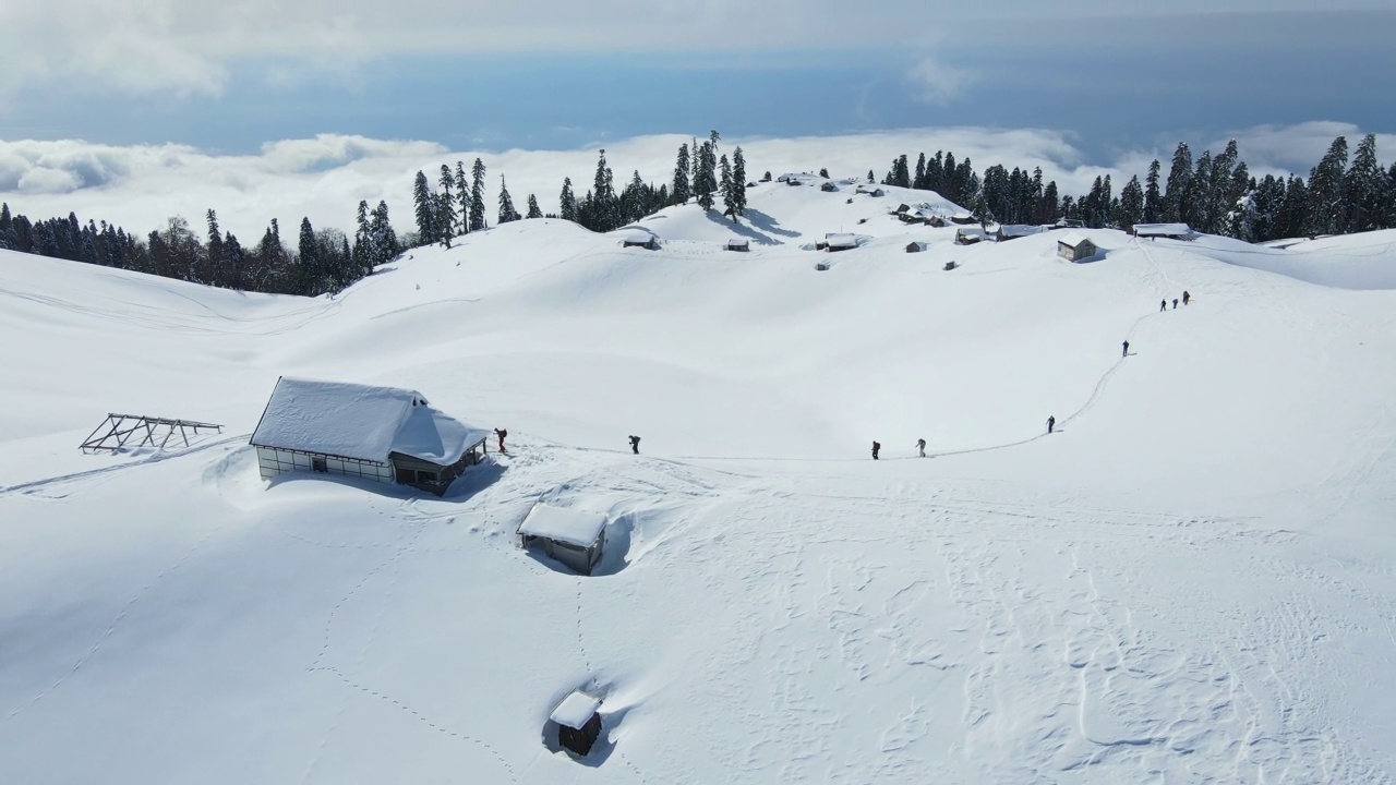 一群滑雪旅游爱好者爬上了积雪覆盖的山顶视频素材