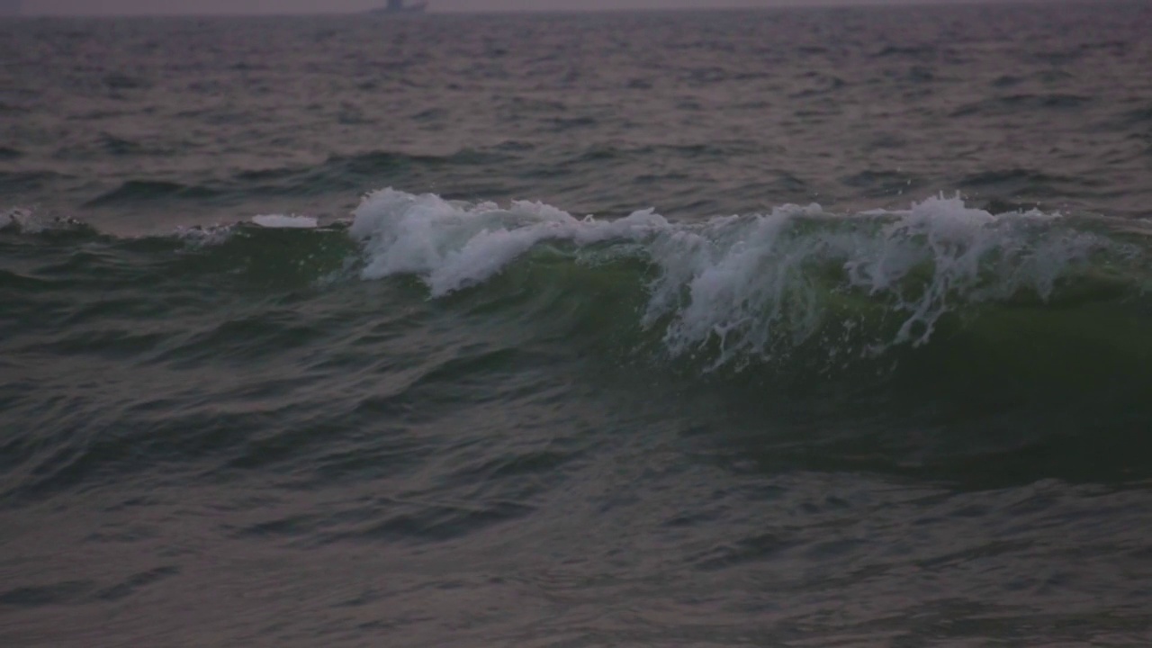 特写一个巨大的强大的海浪在印度果阿海滩的海岸上升的慢动作。海滩上的海浪。日落时由于强风而产生的巨浪。海洋背景。视频素材