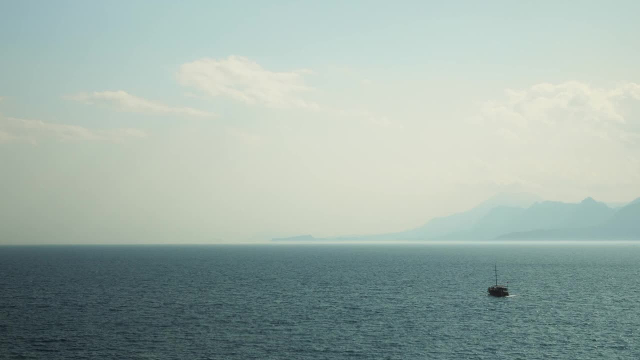 渔船漂浮在泻湖上，时间流逝。在阳光明媚的夏日，小船在群山环绕的湖面上航行。暑假旅游度假概念。娱乐活动视频素材