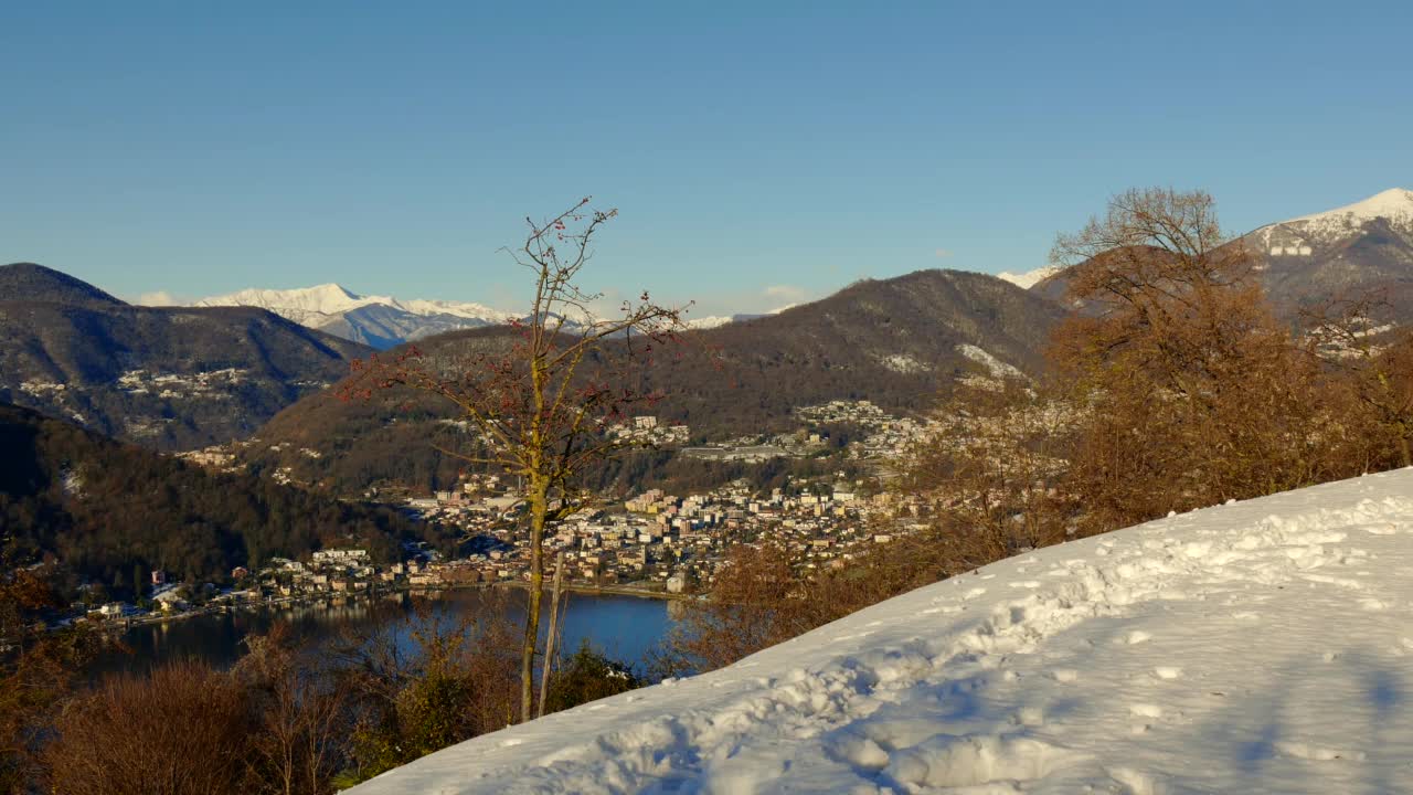 卡萨拉诺市与卢加诺湖和山景与雪和晴朗的蓝天晴天视频素材