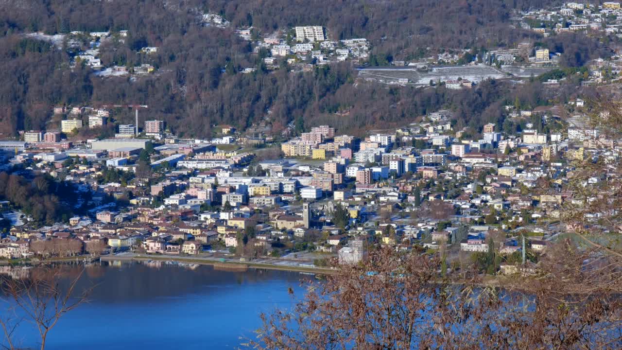 鸟瞰卡萨拉诺市的卢加诺湖和山景与雪和晴朗的蓝天晴天视频素材