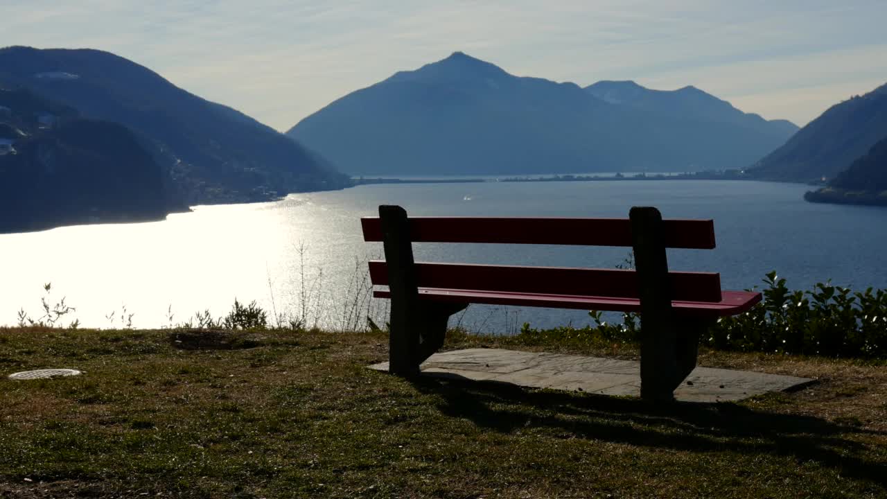 阳光明媚的日子里，卢加诺湖上的山景视频素材