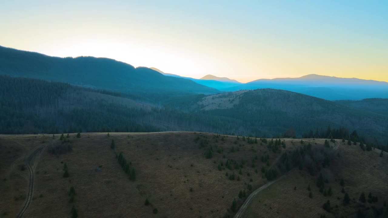 美丽的山脉全景与朦胧的山峰和雾蒙蒙的山谷在日落视频素材