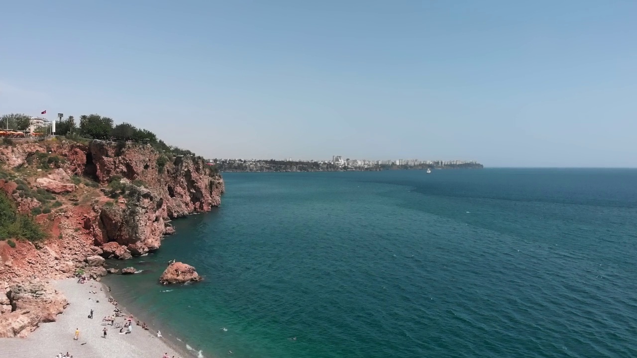 夏季炎热的地中海海岸线。令人惊叹的海滩，岩石，小山和沙滩映衬着清澈的蓝天。娱乐休闲活动。美丽的自然景观与大海视频素材