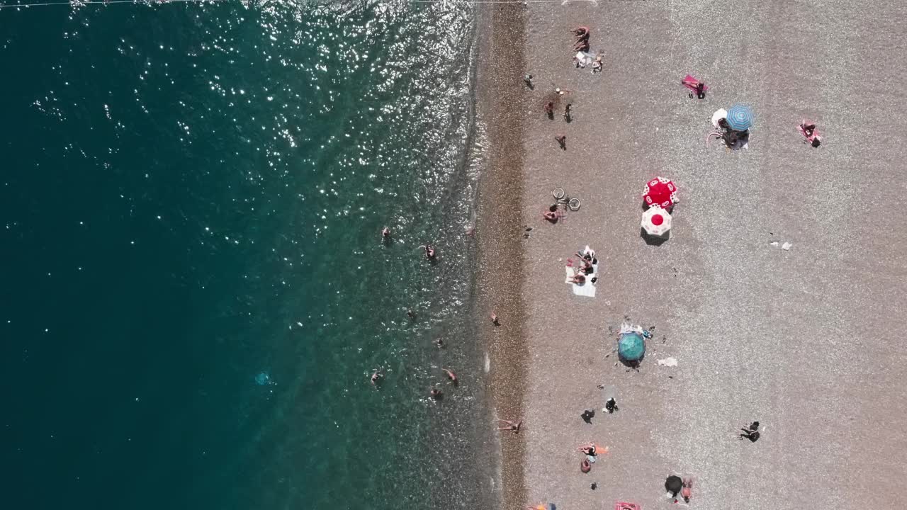 地中海沿岸的沙滩，海面平静。夏天人们在海滩上乘凉。夏季海滩度假概念。热带夏季旅游胜地。神奇的海景视频素材