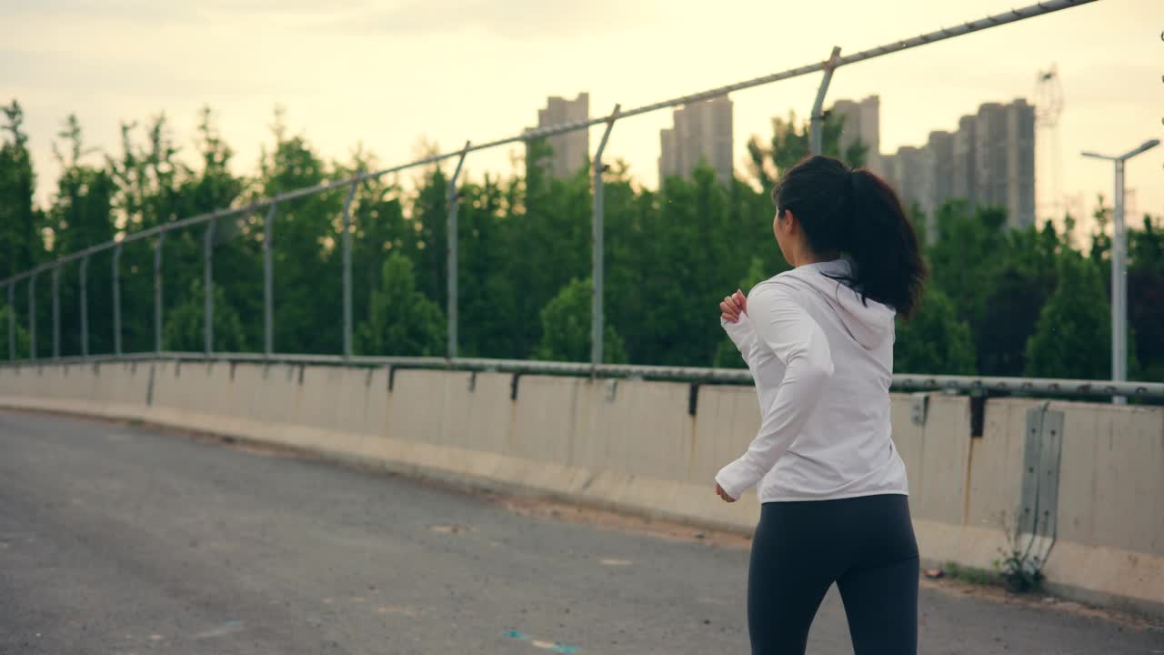 女子跑过城市人行天桥视频素材