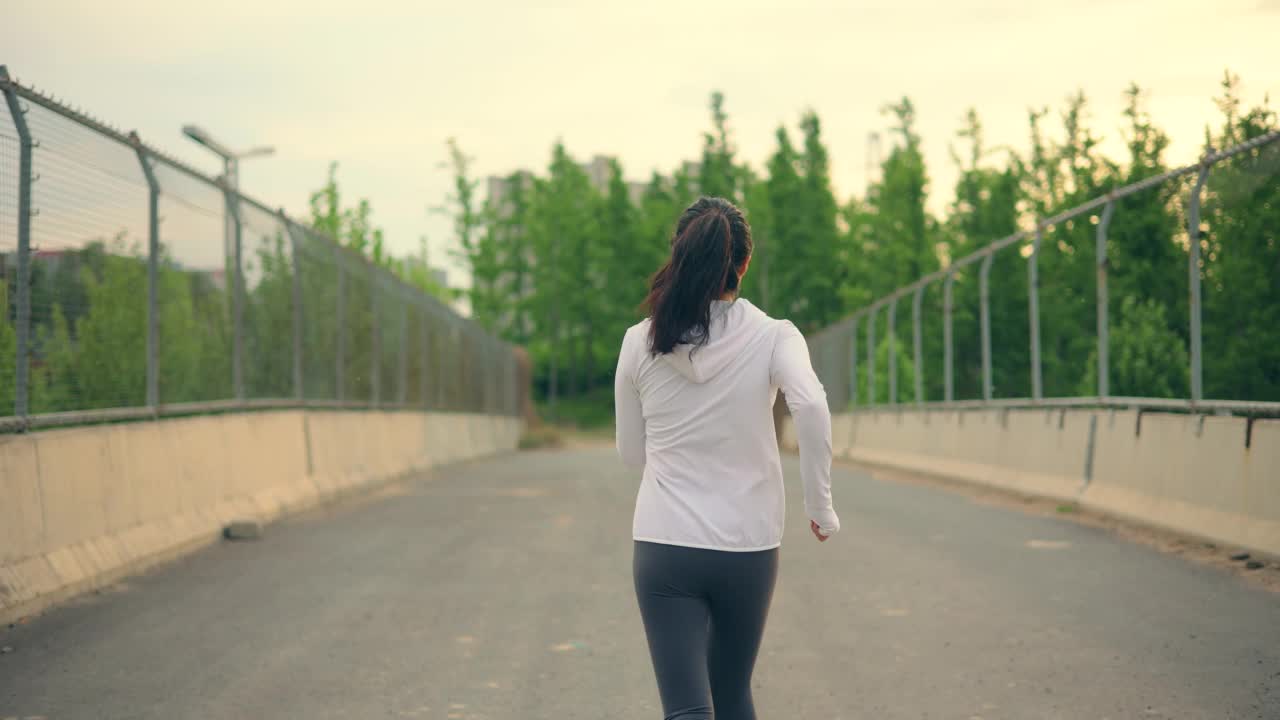 女子跑过城市人行天桥视频素材